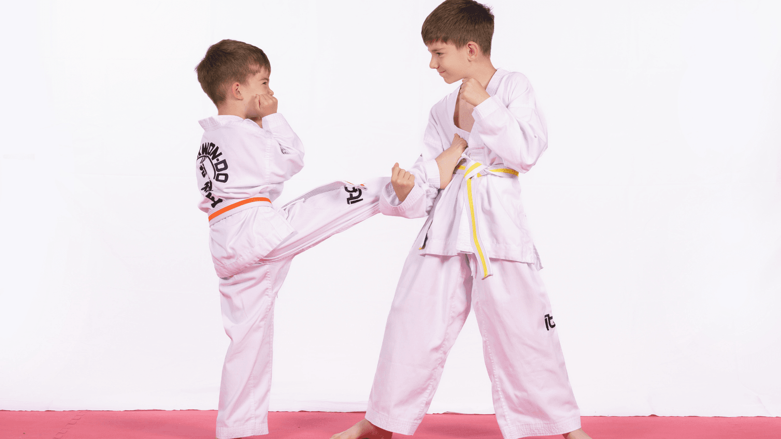Two boys in white gi practising stand-up sparring.